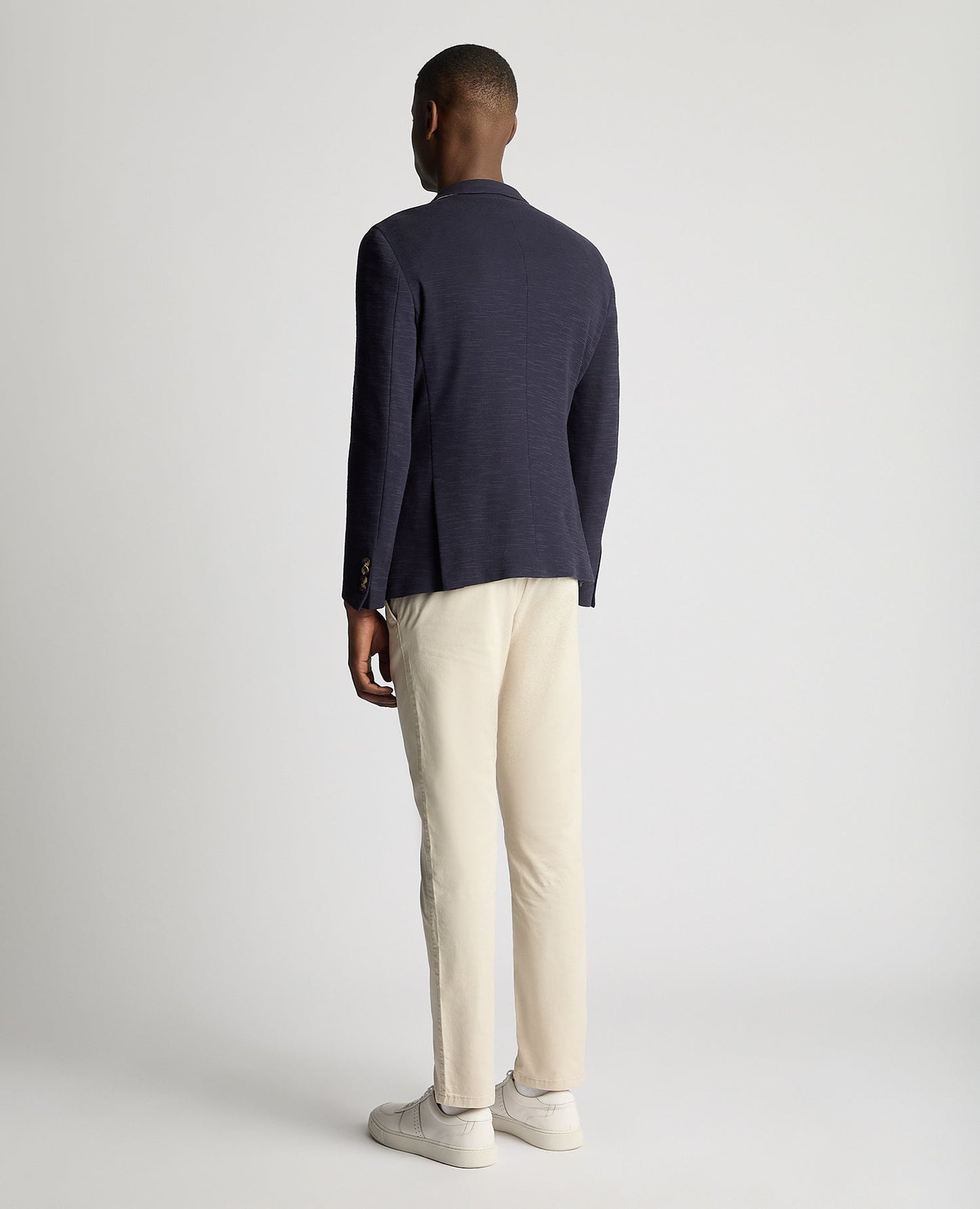 Man wearing a navy Slim Fit Cotton-Stretch Double Breasted Jacket