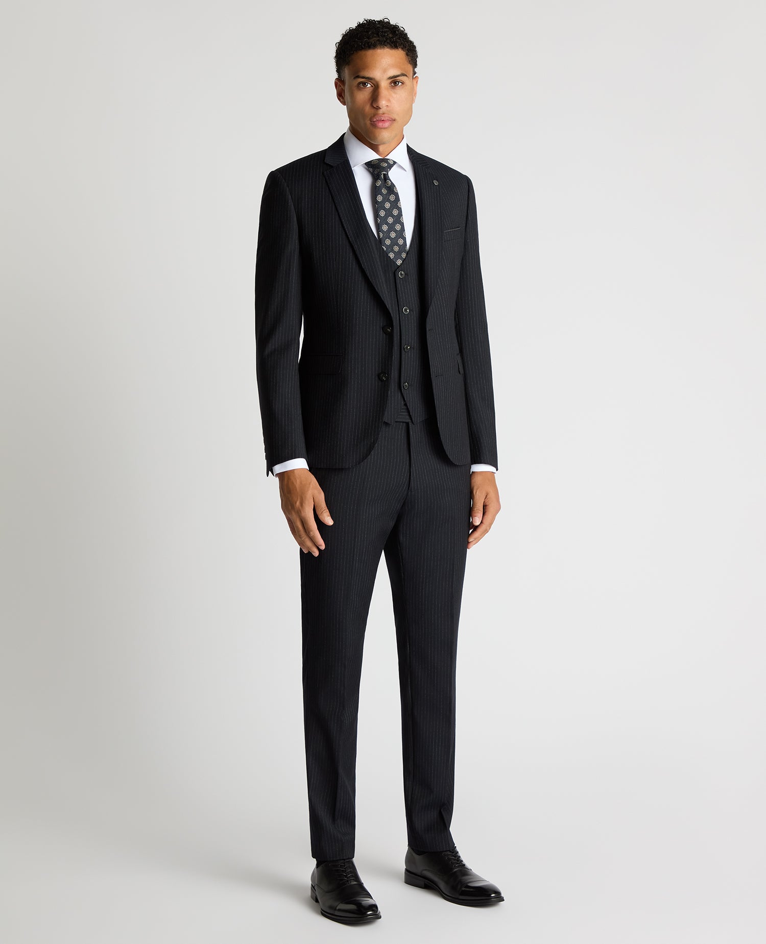 Man wearing a navy Slim Fit Pinstripe Wool Rich Suit