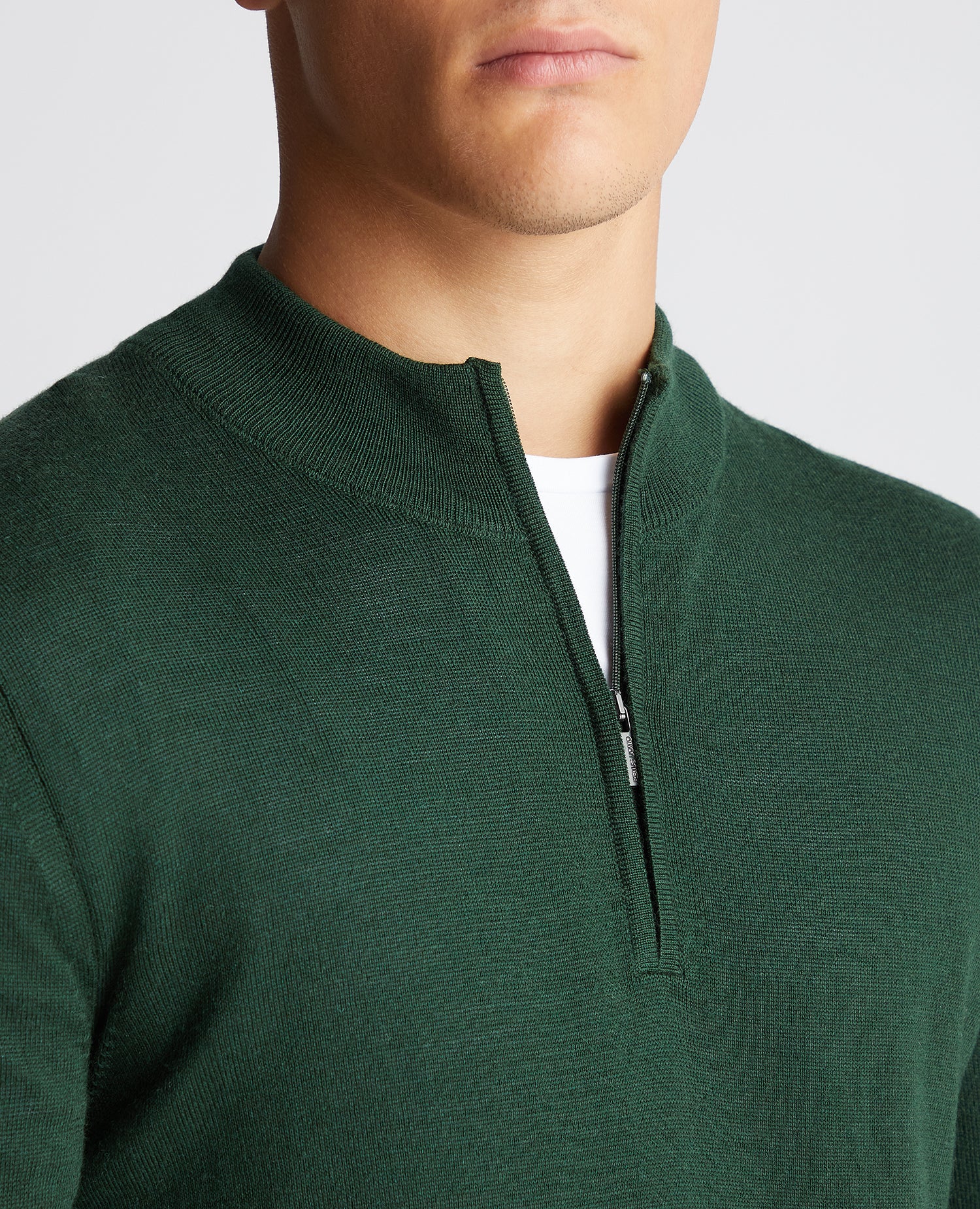 Man wearing a green Tapered Fit Merino Wool-Blend Half Zip Sweater