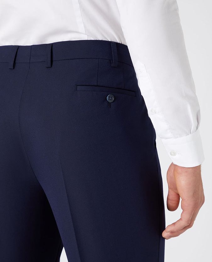 Man wearing a navy Tapered Leg Stretch Formal Trousers .