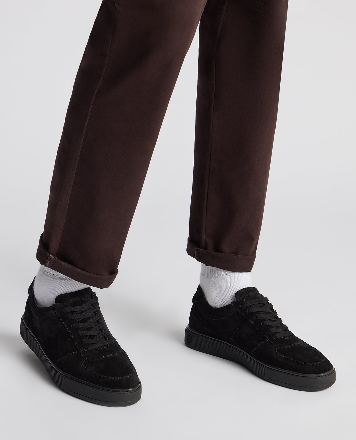 Man wearing a black Suede Enrico Trainer