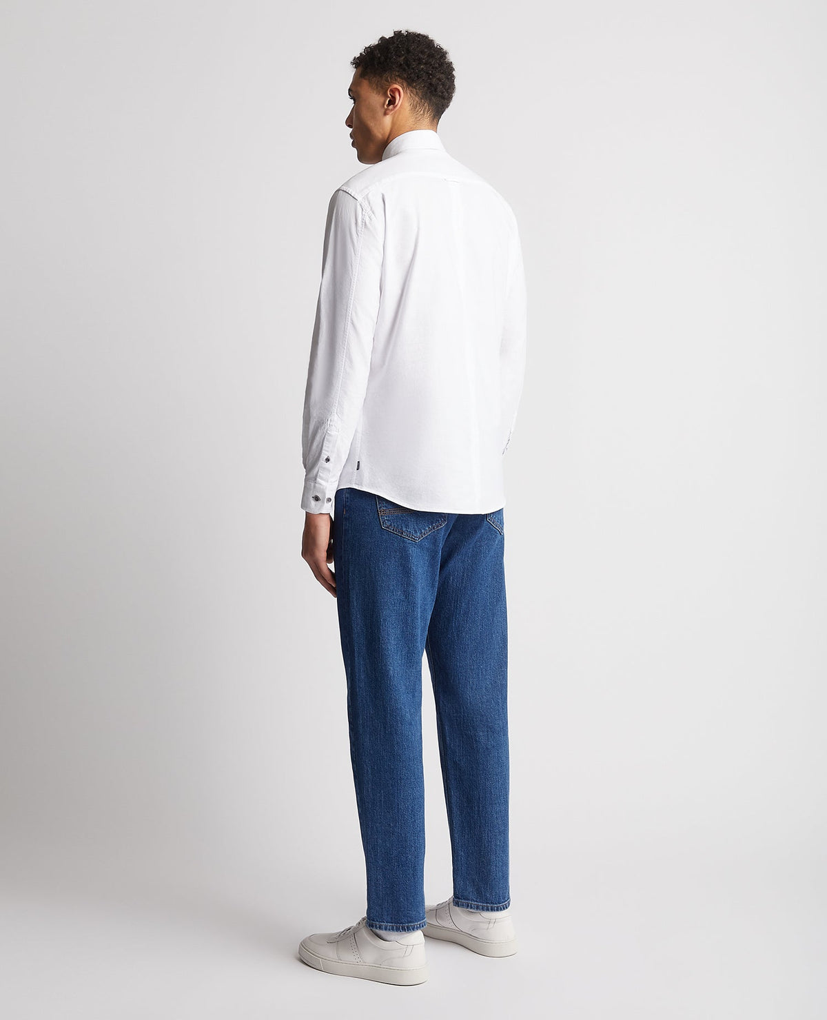 Man wearing a white Tapered Fit Oxford Cotton Shirt