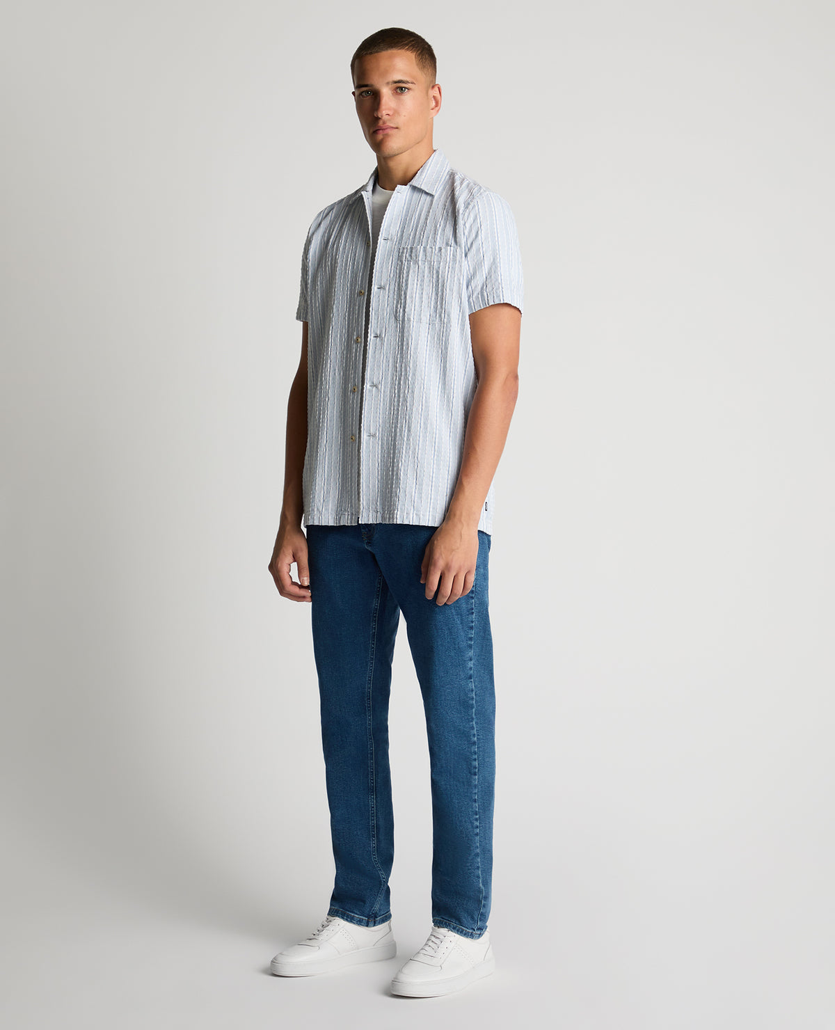 Man wearing a blue Tapered Fit Striped Seersucker Shirt