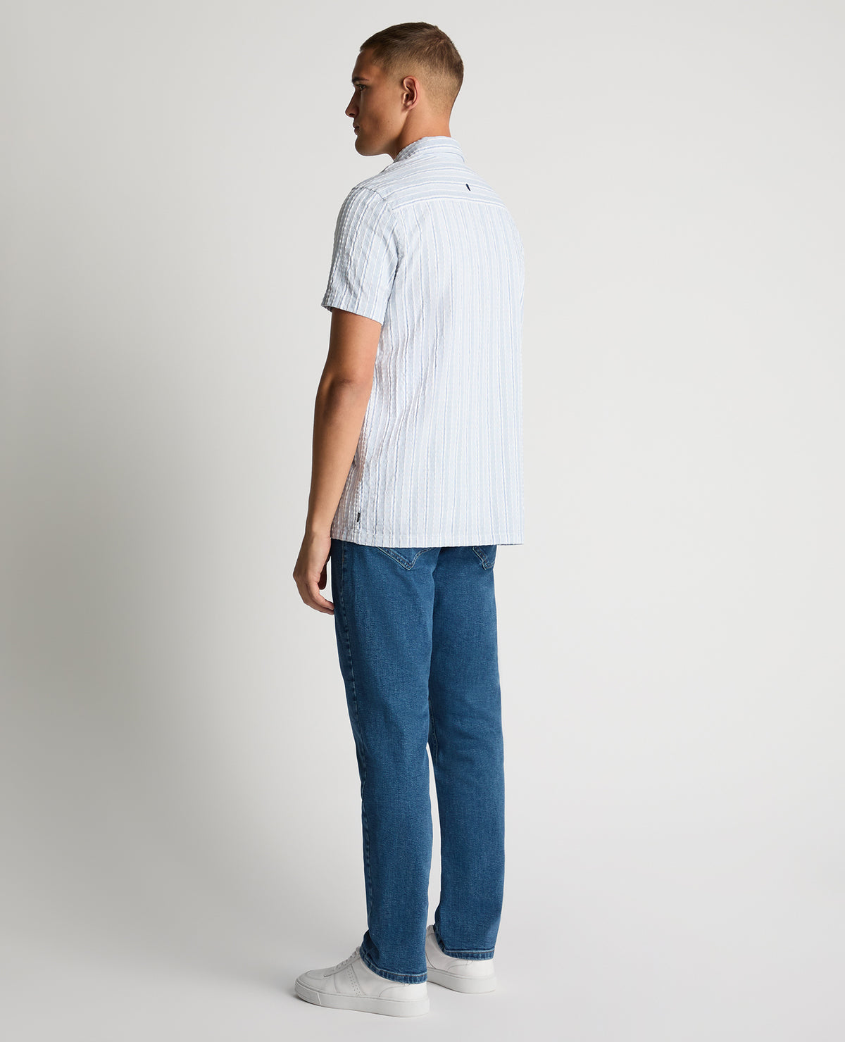 Man wearing a blue Tapered Fit Striped Seersucker Shirt