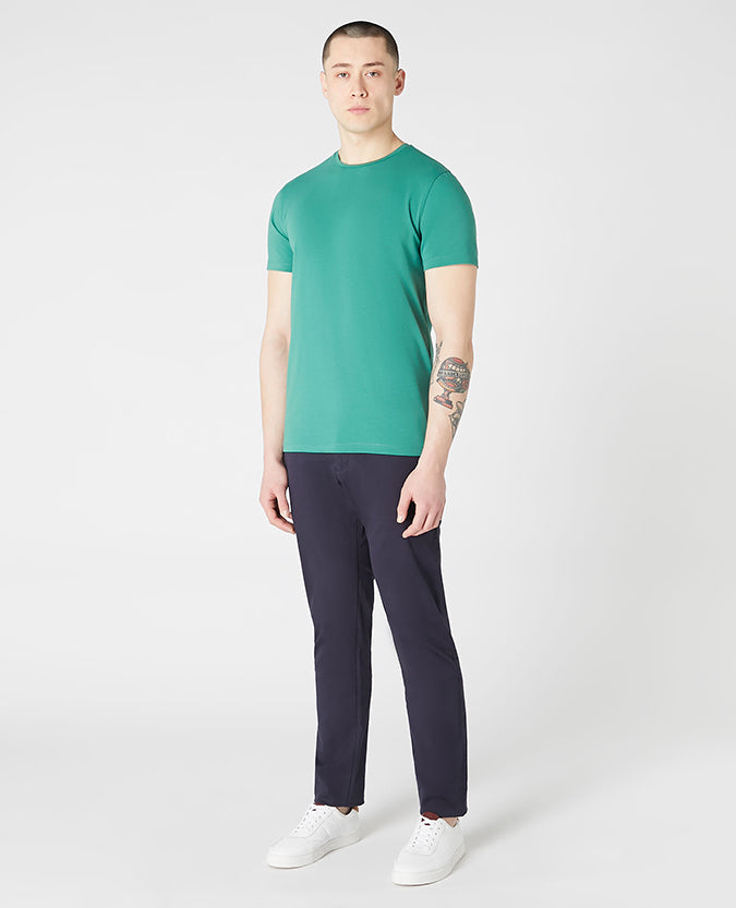 Man wearing a green Tapered Fit Cotton-Stretch T-Shirt
