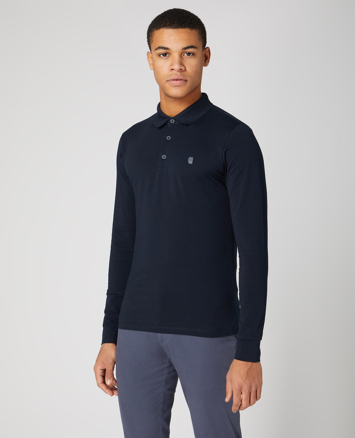 Man wearing a navy Tapered Fit Cotton-Stretch Long-Sleeve Polo Shirt