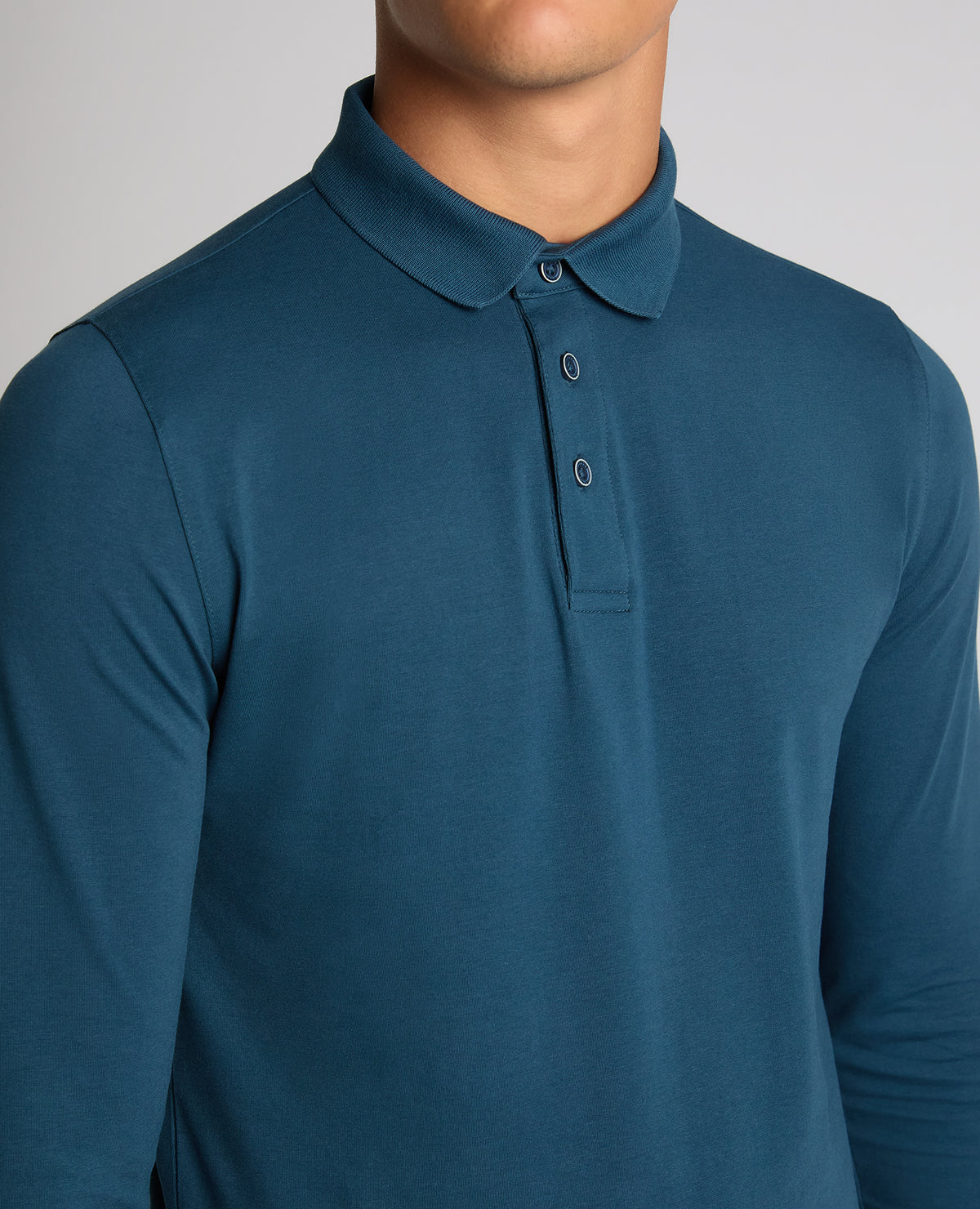 Man wearing a blue Tapered Fit Cotton-Stretch Polo Shirt