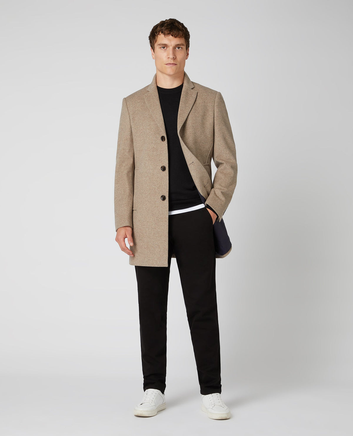 Man wearing a black Tapered Fit Merino Wool-Blend Crew Neck Sweater