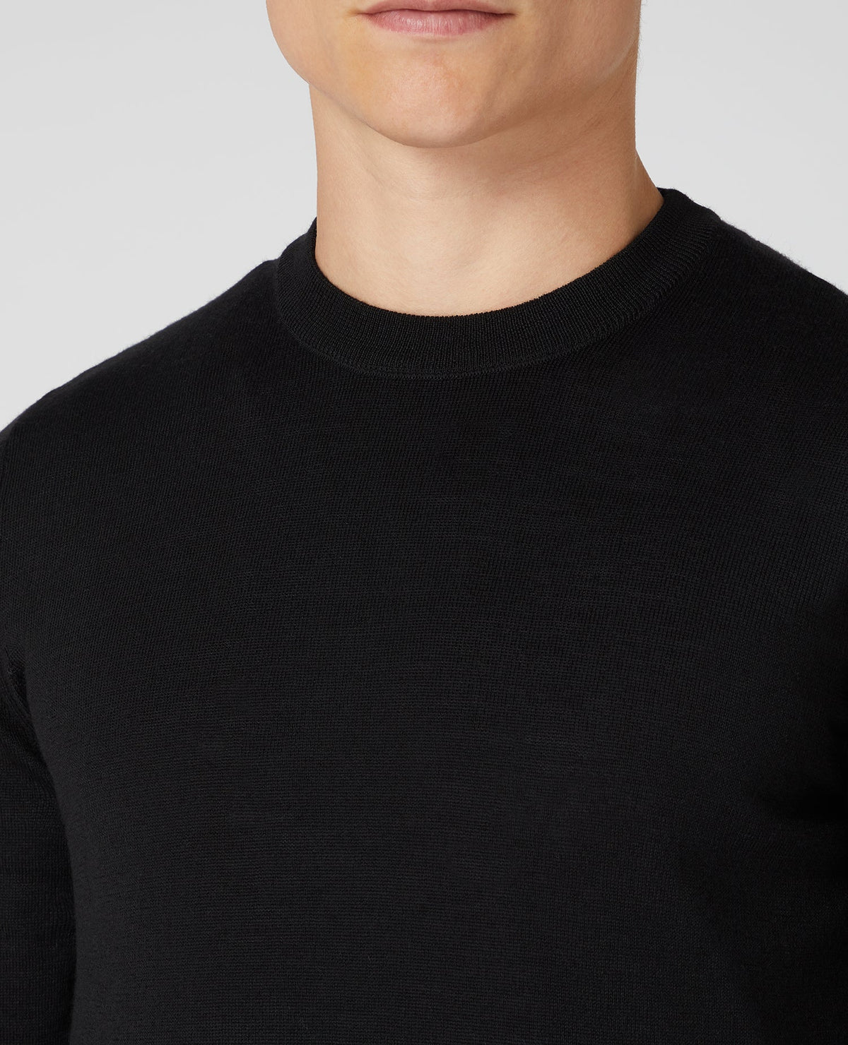 Man wearing a black Tapered Fit Merino Wool-Blend Crew Neck Sweater