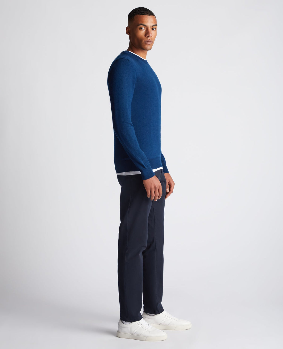 Man wearing a blue Tapered Fit Merino Wool-Blend Crew Neck Sweater