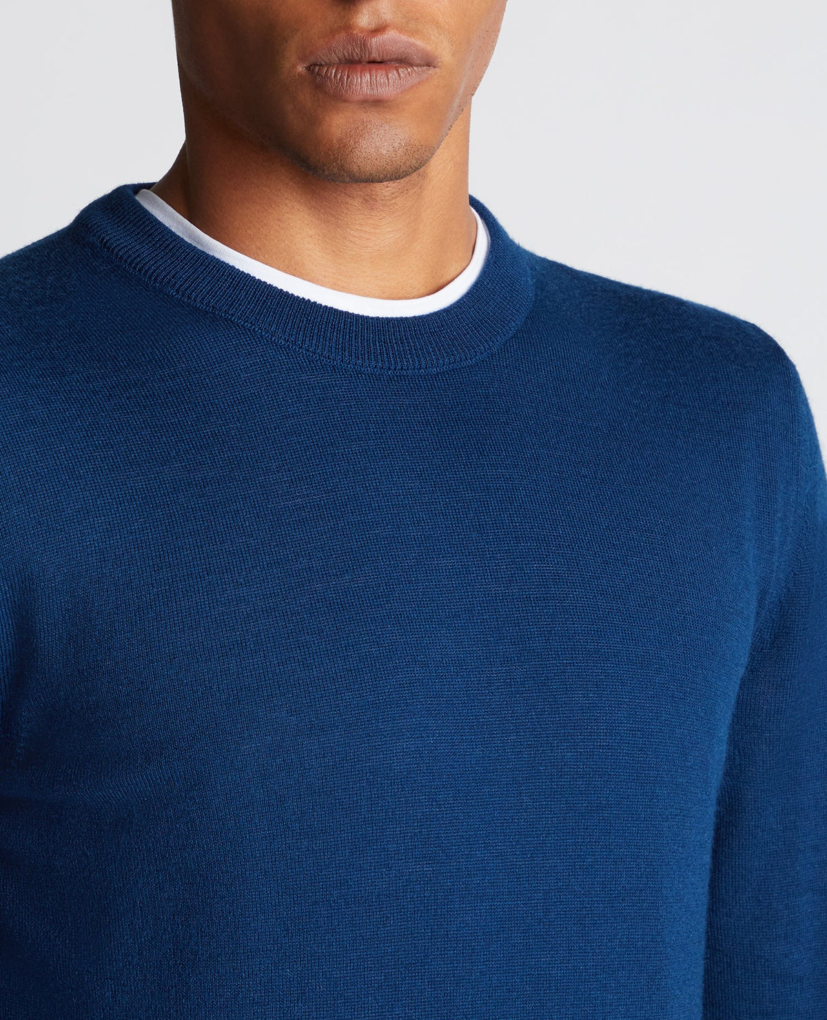 Man wearing a blue Tapered Fit Merino Wool-Blend Crew Neck Sweater
