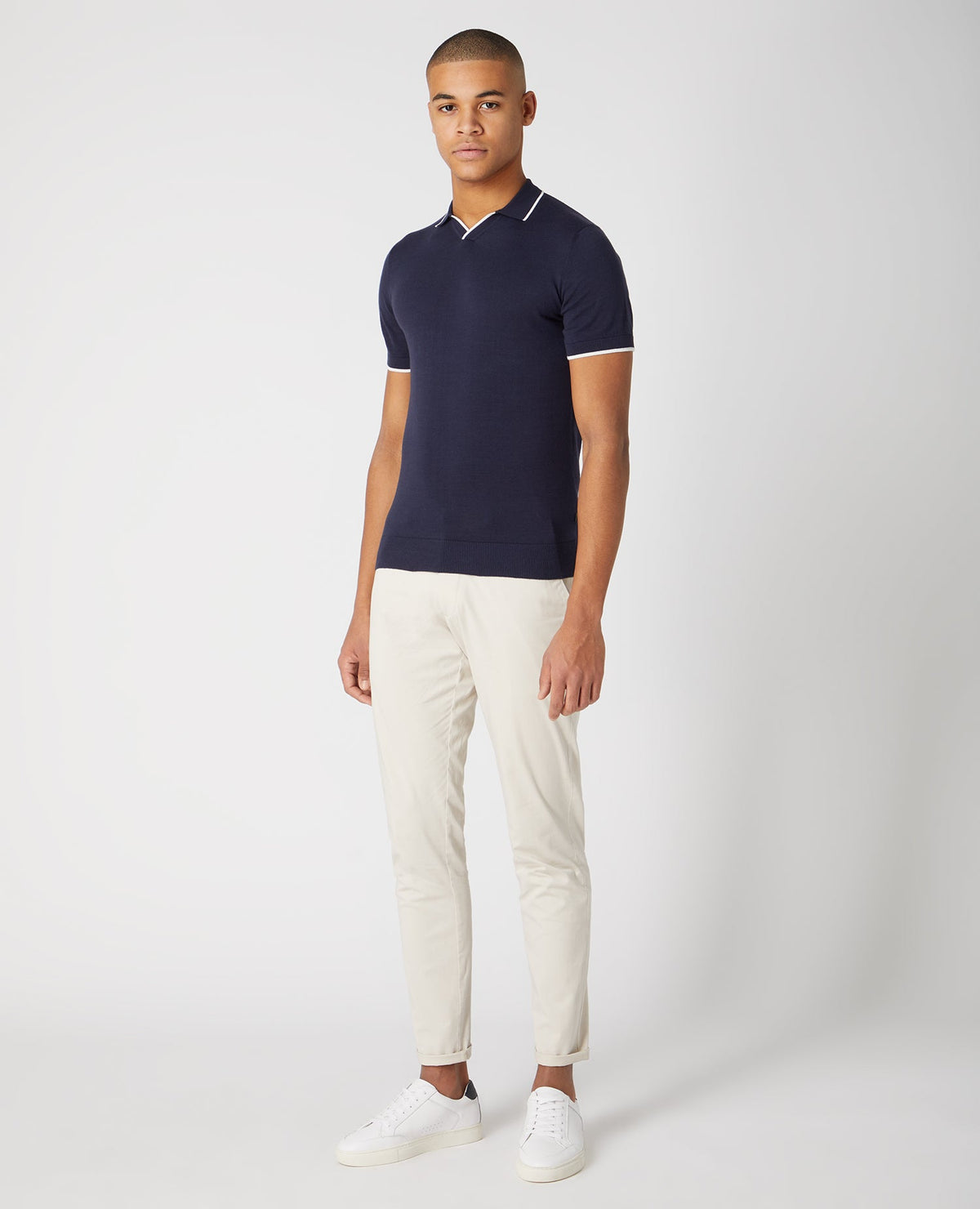 Man wearing a navy Slim Fit Knitted Cotton Short Sleeve Polo Shirt