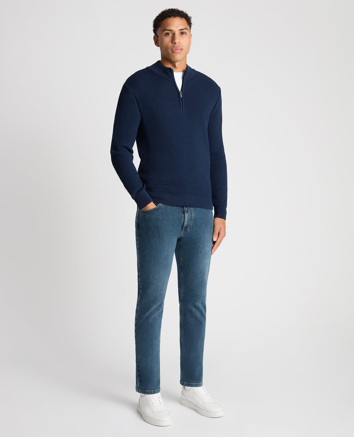 Man wearing a blue Tapered Fit Merino Half Zip Sweater