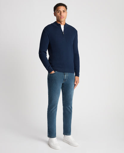 Man wearing a blue Tapered Fit Merino Half Zip Sweater