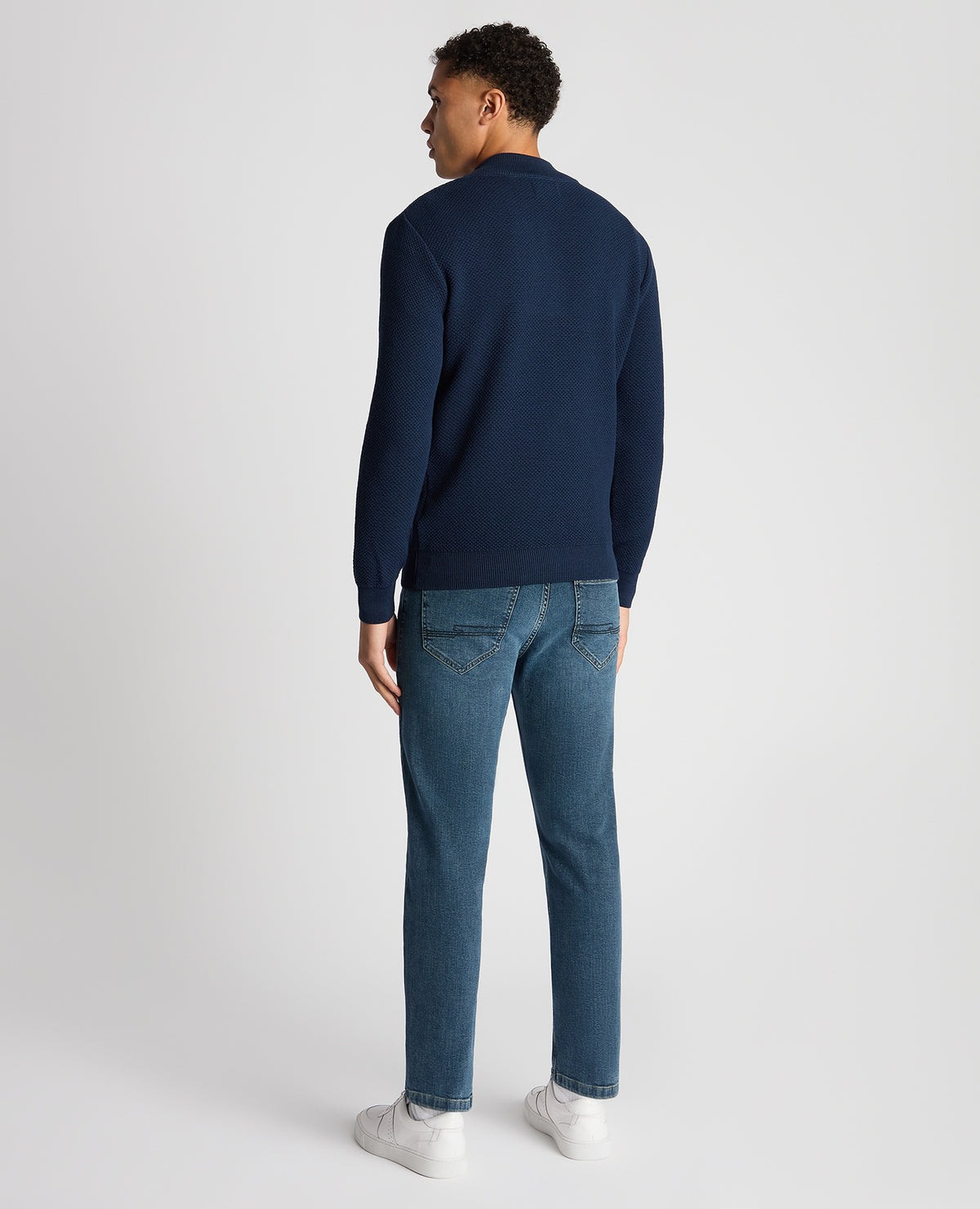 Man wearing a blue Tapered Fit Merino Half Zip Sweater