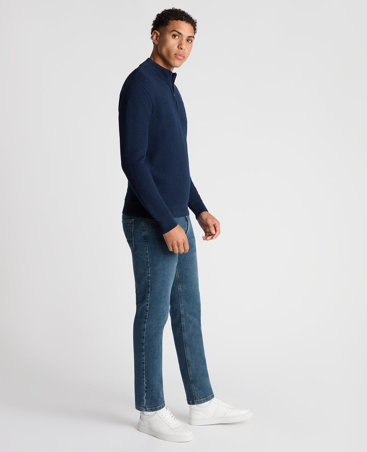 Man wearing a blue Tapered Fit Merino Half Zip Sweater