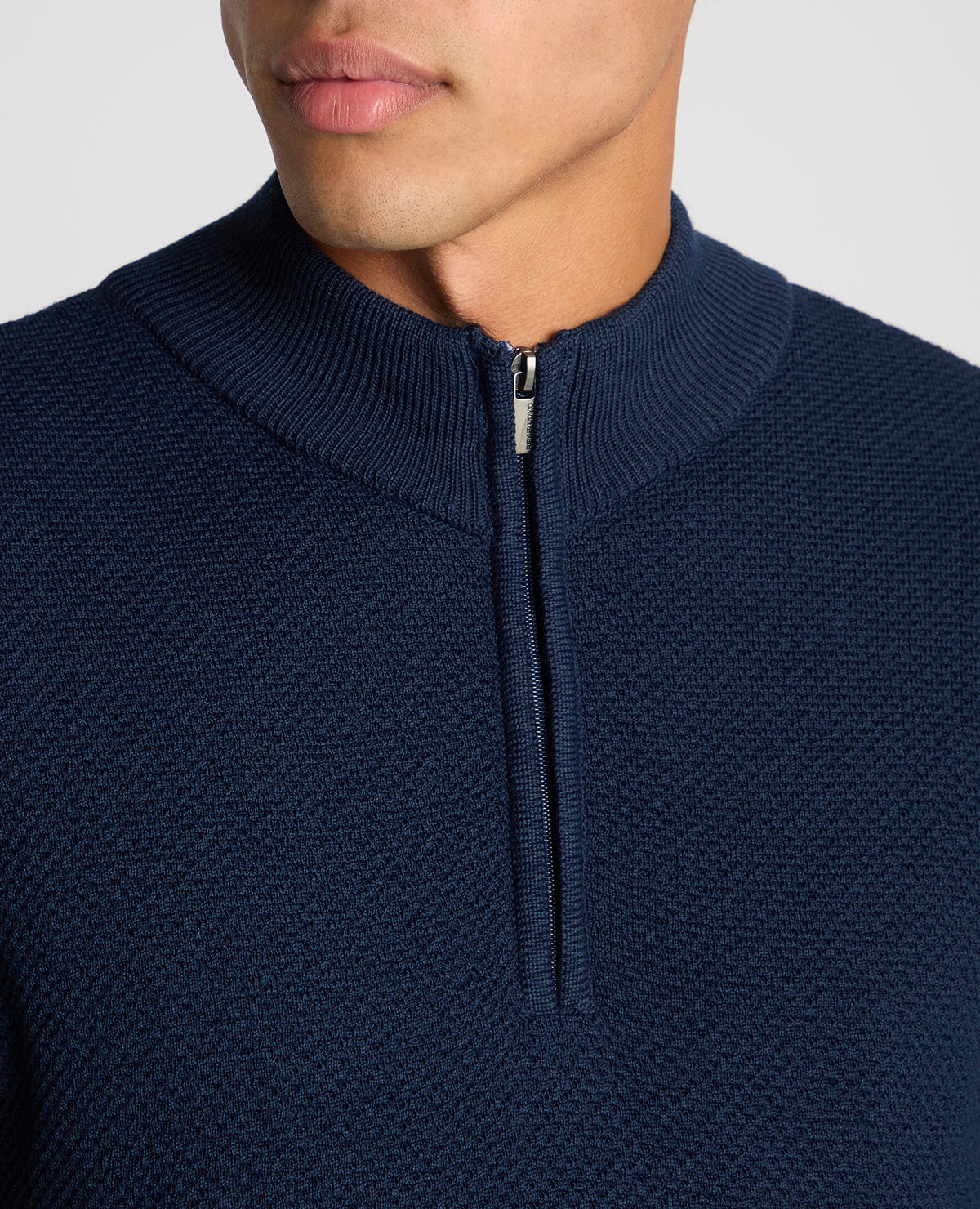 Man wearing a blue Tapered Fit Merino Half Zip Sweater
