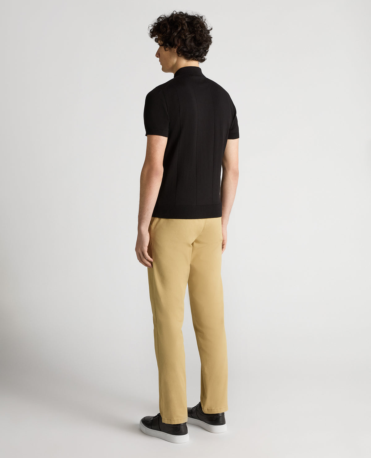 Man wearing a black Slim Fit Knitted Cotton Short-Sleeve Polo