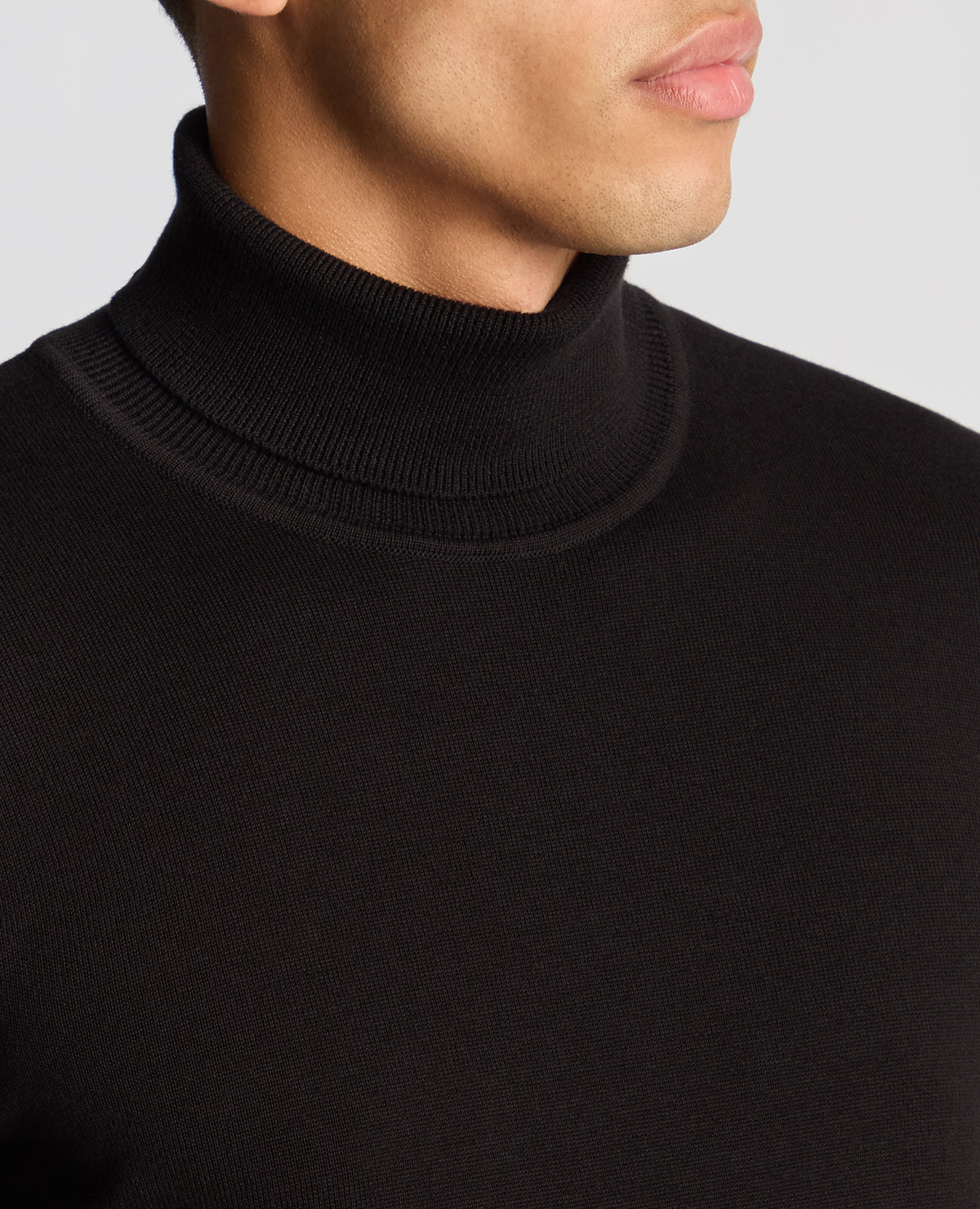 Man wearing a black Tapered Fit Roll Neck Sweater