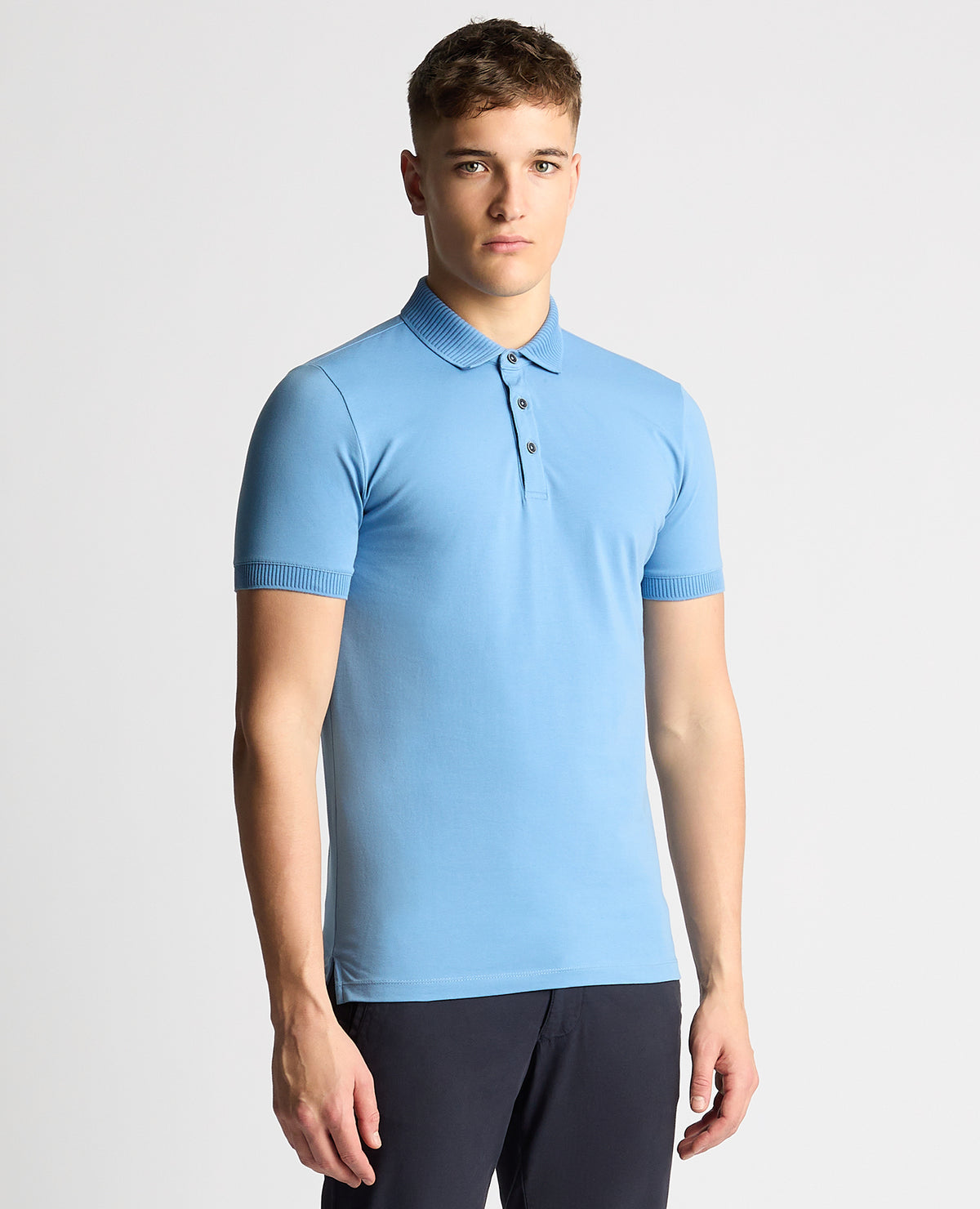 Man wearing a blue Tapered Fit Cotton-Stretch Polo Shirt