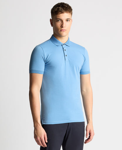 Man wearing a blue Tapered Fit Cotton-Stretch Polo Shirt