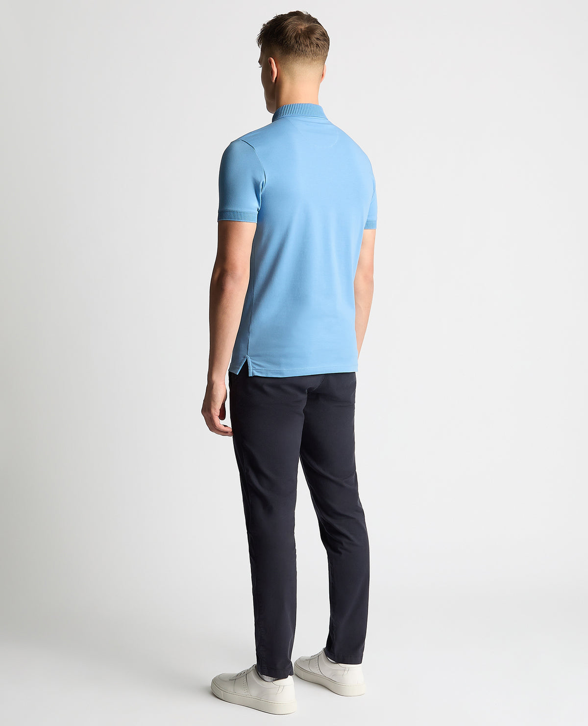 Man wearing a blue Tapered Fit Cotton-Stretch Polo Shirt
