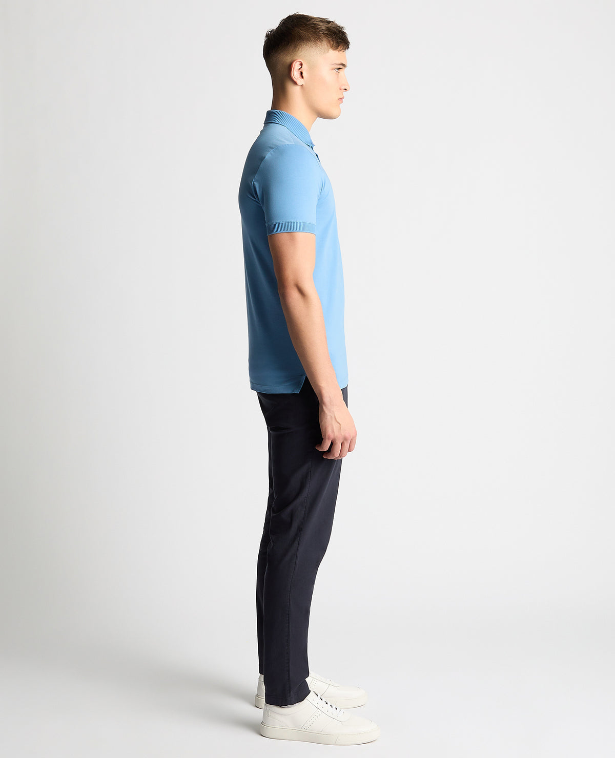 Man wearing a blue Tapered Fit Cotton-Stretch Polo Shirt