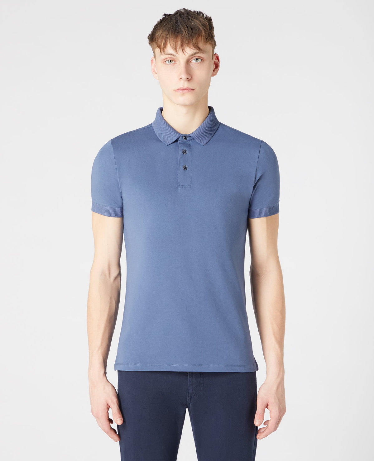 Man wearing a blue Tapered Fit Cotton-Stretch Polo Shirt