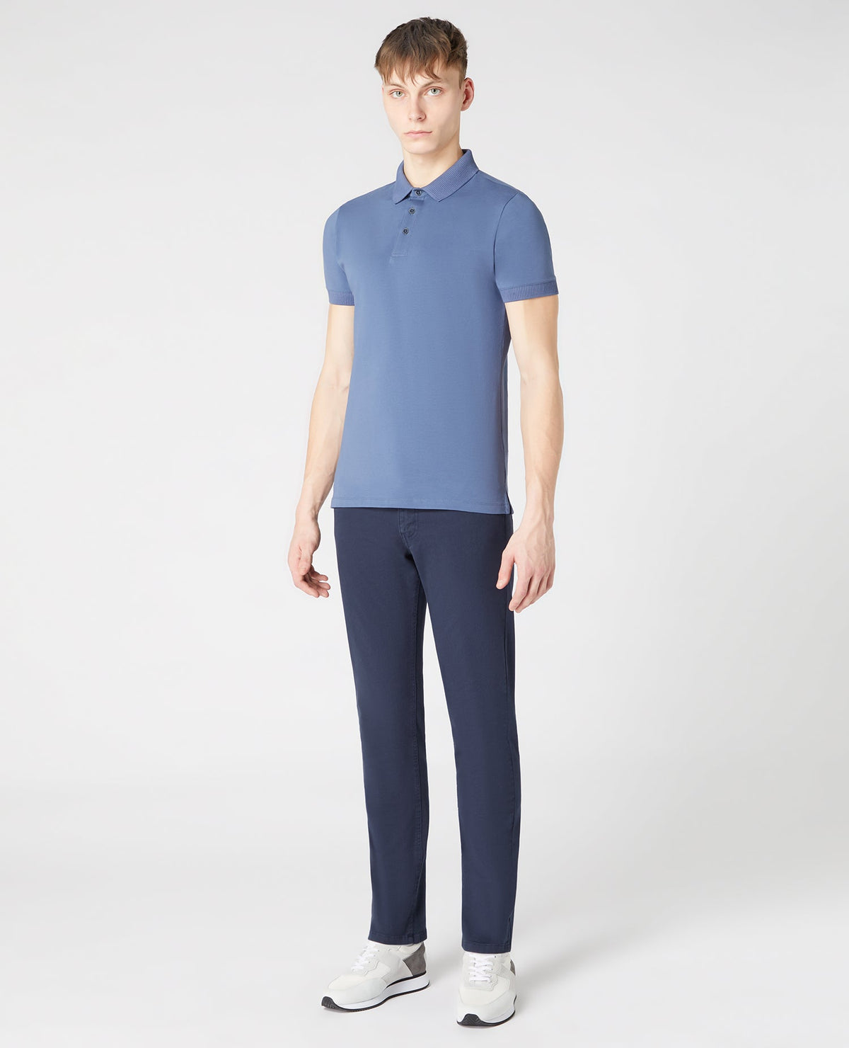 Man wearing a blue Tapered Fit Cotton-Stretch Polo Shirt