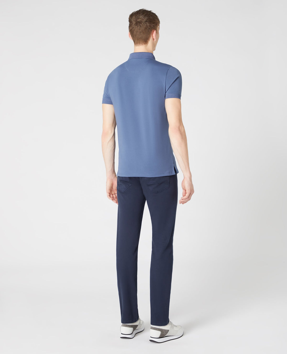 Man wearing a blue Tapered Fit Cotton-Stretch Polo Shirt
