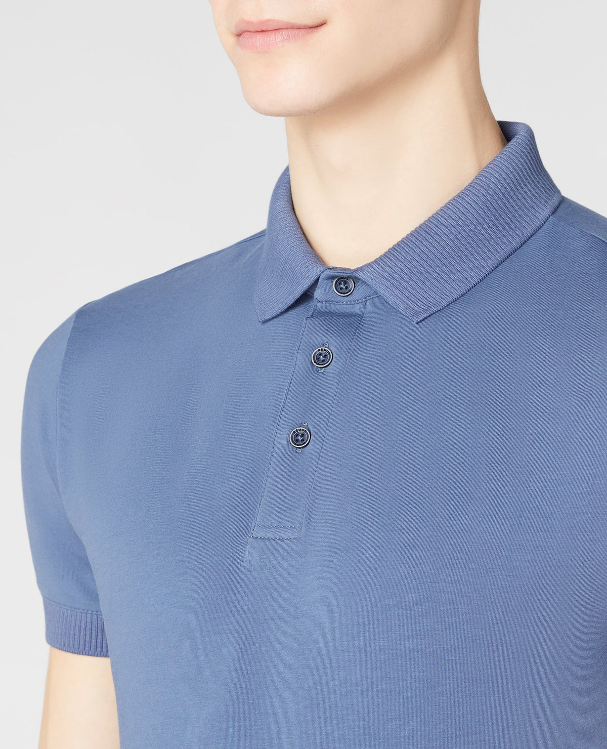 Man wearing a blue Tapered Fit Cotton-Stretch Polo Shirt