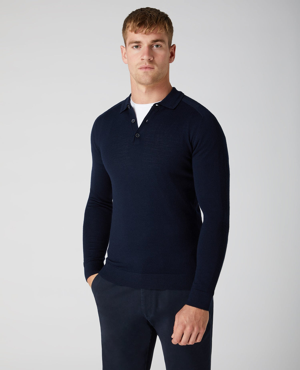 Man wearing a navy Slim Fit Merino Wool-Blend Long Sleeve Knitted Polo