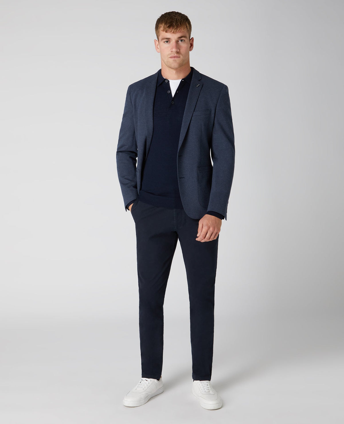 Man wearing a navy Slim Fit Merino Wool-Blend Long Sleeve Knitted Polo