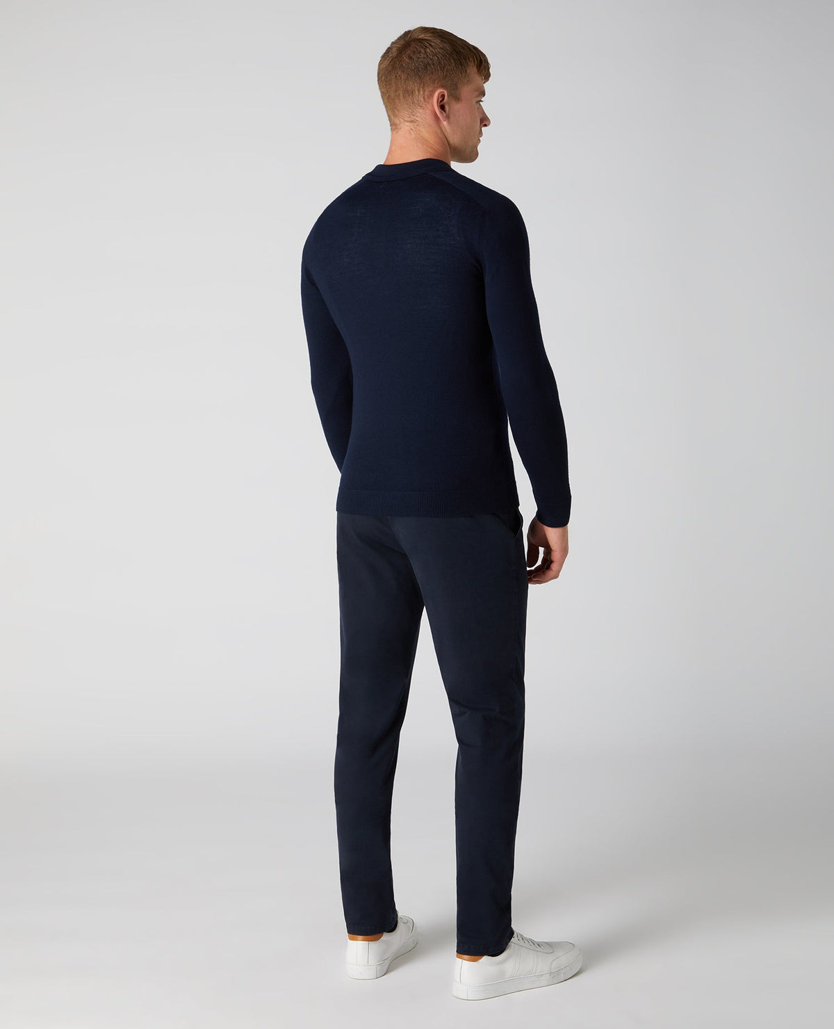 Man wearing a navy Slim Fit Merino Wool-Blend Long Sleeve Knitted Polo