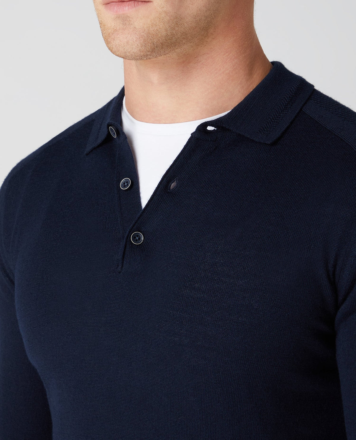 Man wearing a navy Slim Fit Merino Wool-Blend Long Sleeve Knitted Polo