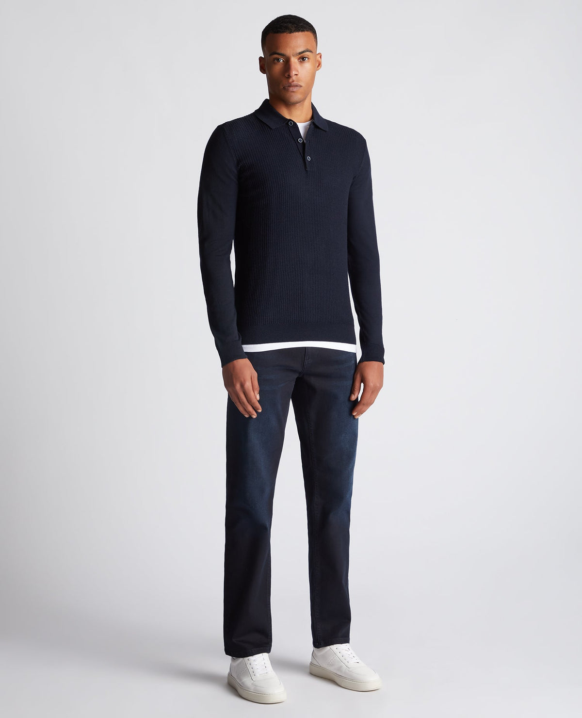 Man wearing a navy Slim Fit Merino Wool-Blend Long Sleeve Knitted Polo