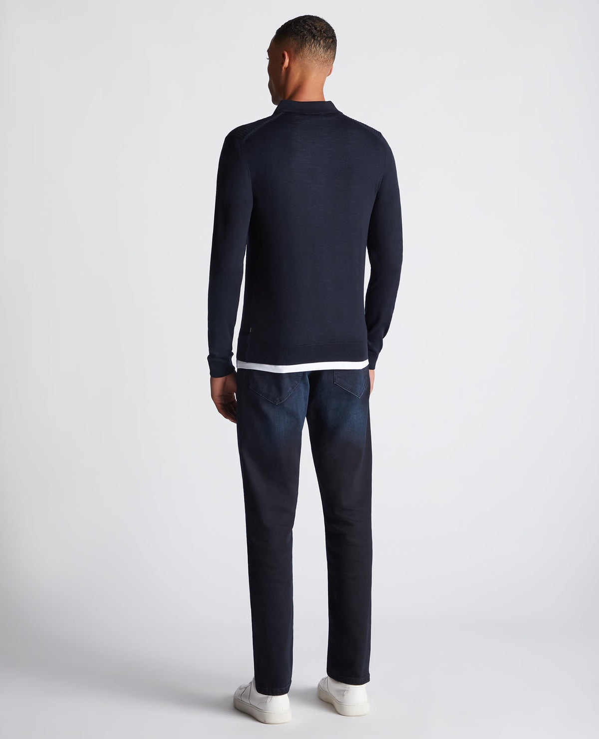 Man wearing a navy Slim Fit Merino Wool-Blend Long Sleeve Knitted Polo