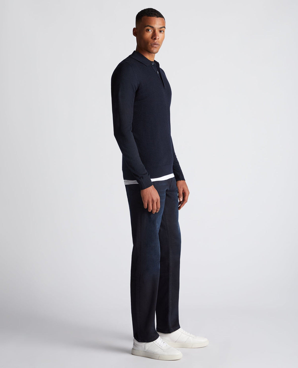 Man wearing a navy Slim Fit Merino Wool-Blend Long Sleeve Knitted Polo