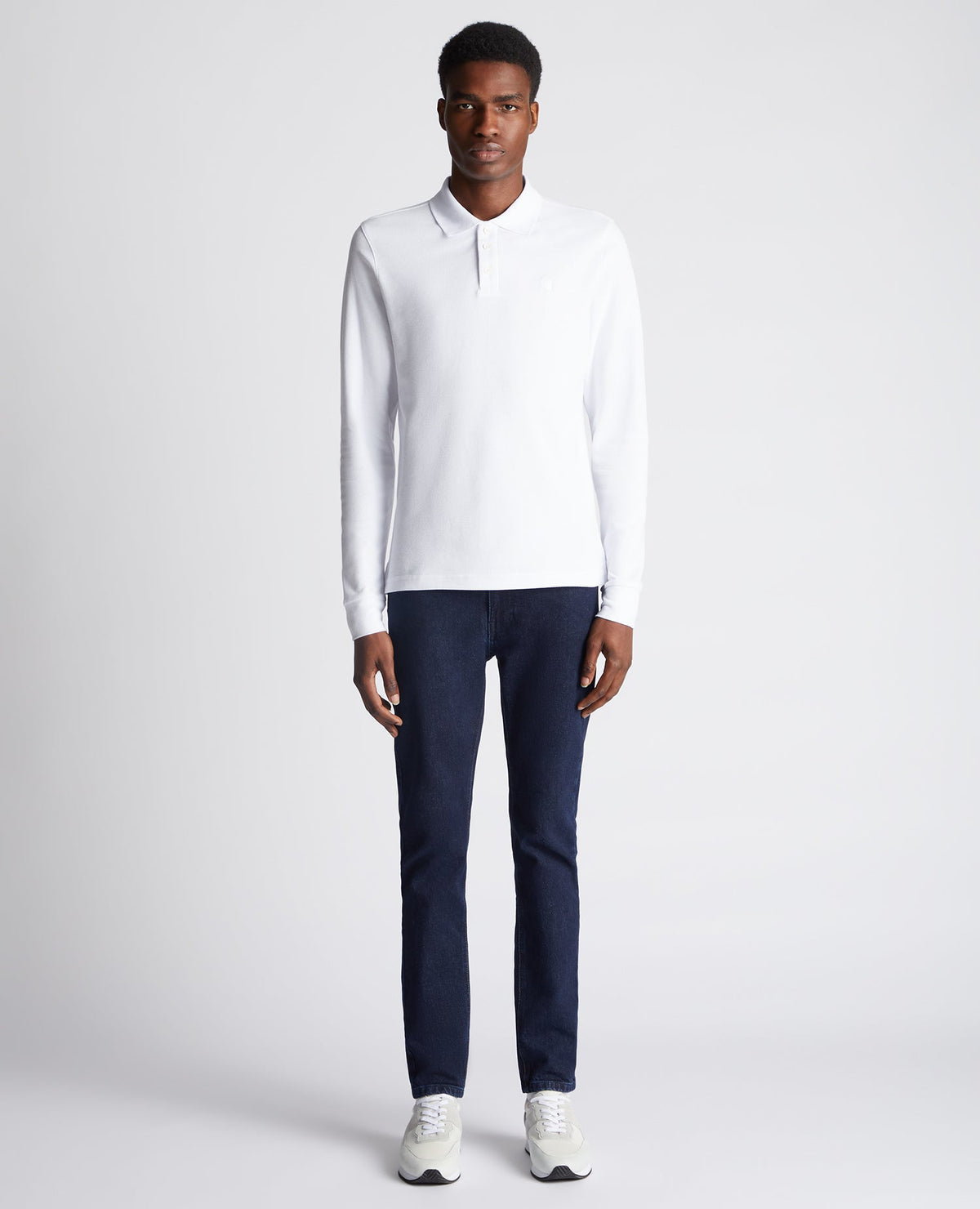 Man wearing a white Slim Fit Cotton-Stretch Pique Polo Shirt