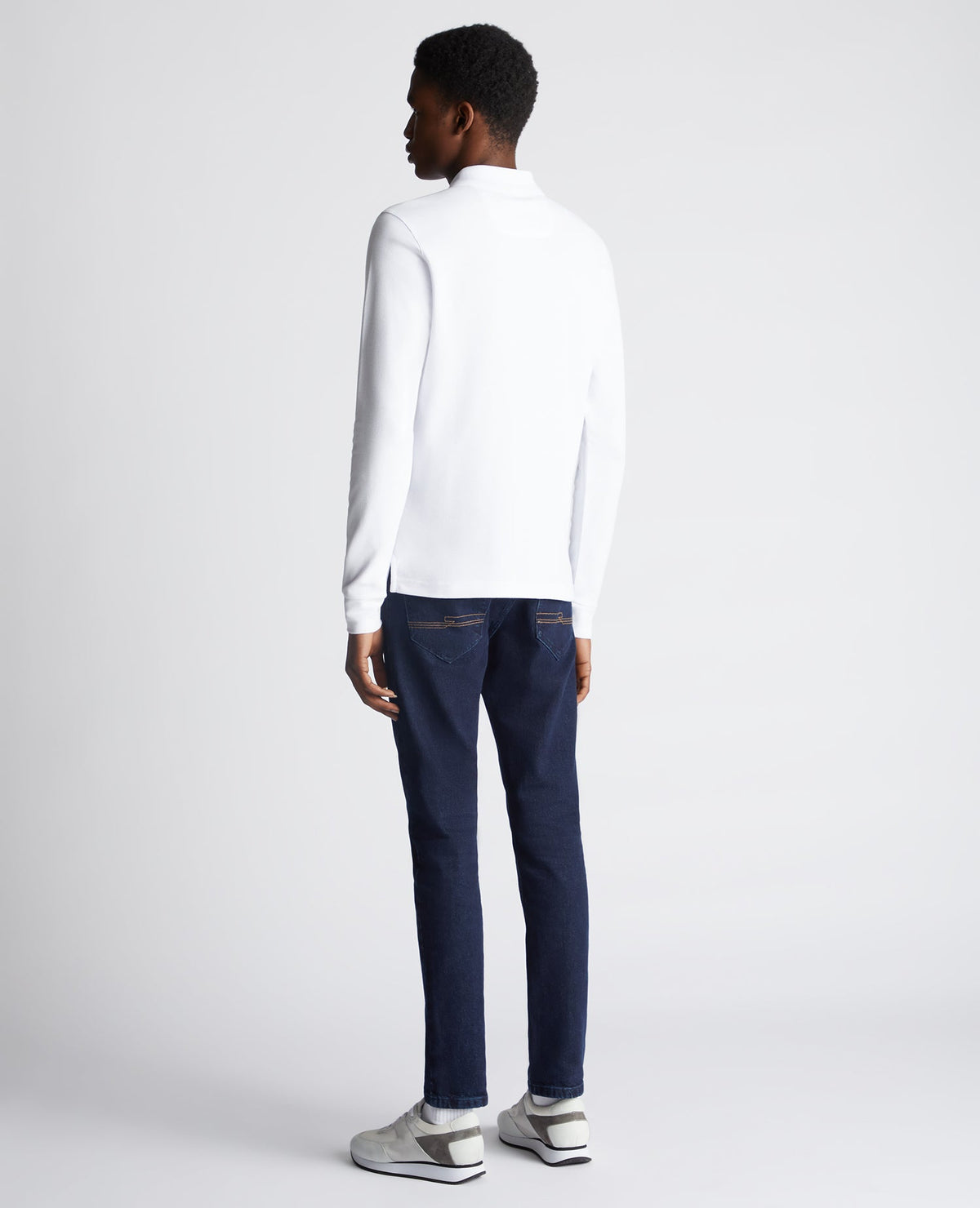 Man wearing a white Slim Fit Cotton-Stretch Pique Polo Shirt