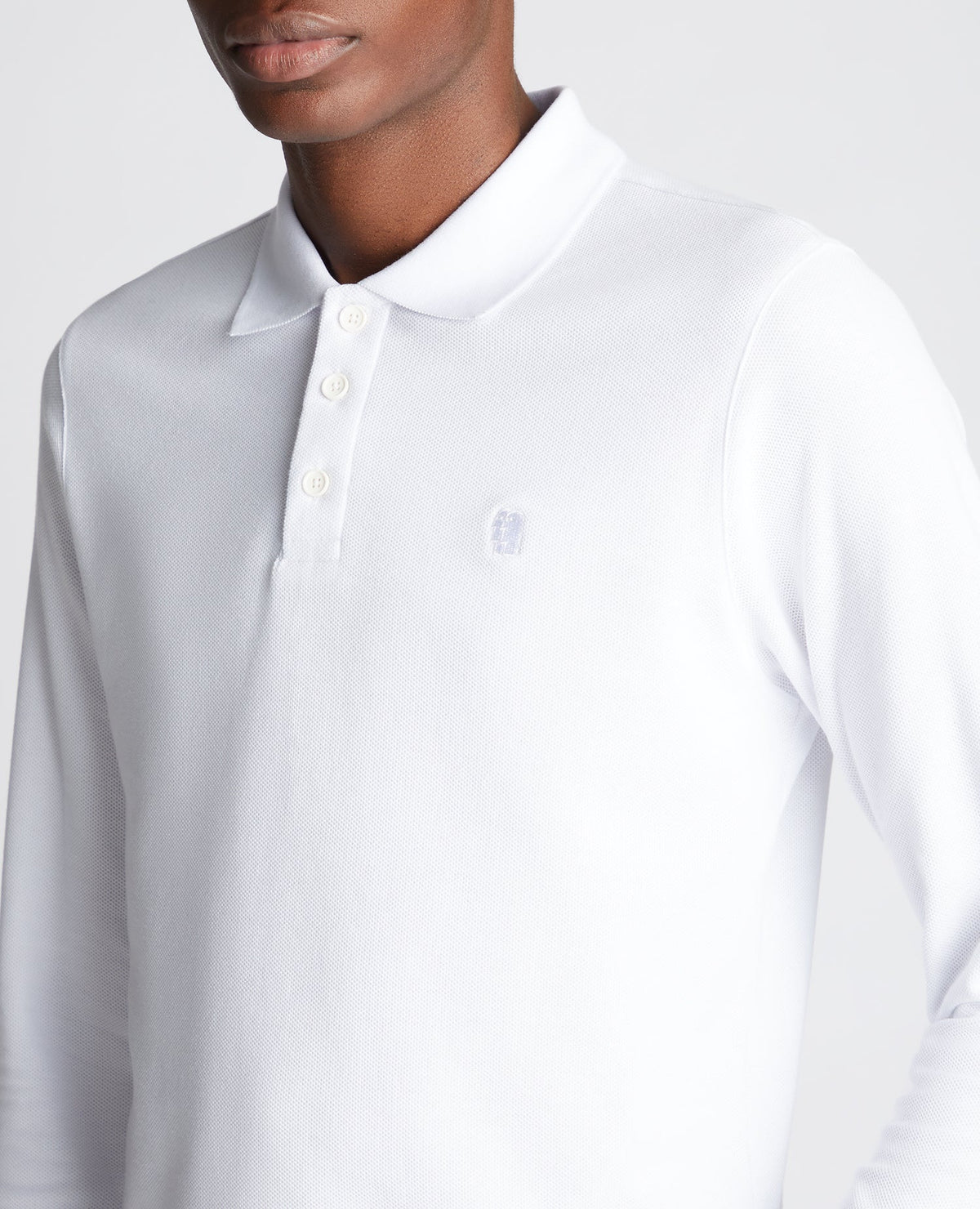 Man wearing a white Slim Fit Cotton-Stretch Pique Polo Shirt