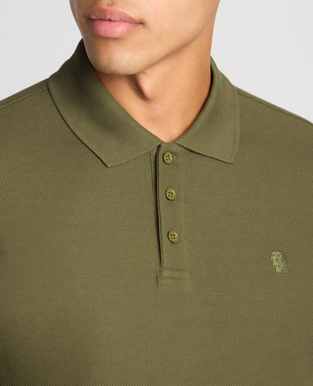Man wearing a green Slim Fit Cotton-Stretch Pique Polo Shirt