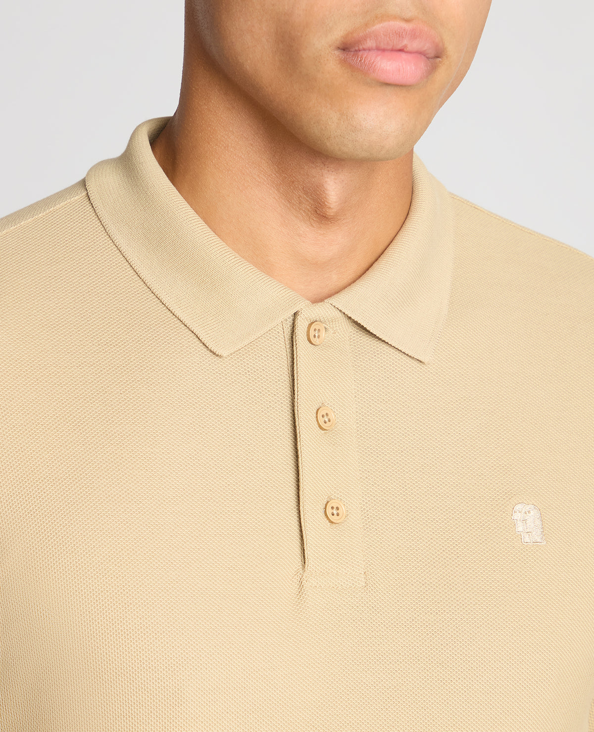 Man wearing a sand Slim Fit Cotton-Stretch Pique Polo Shirt