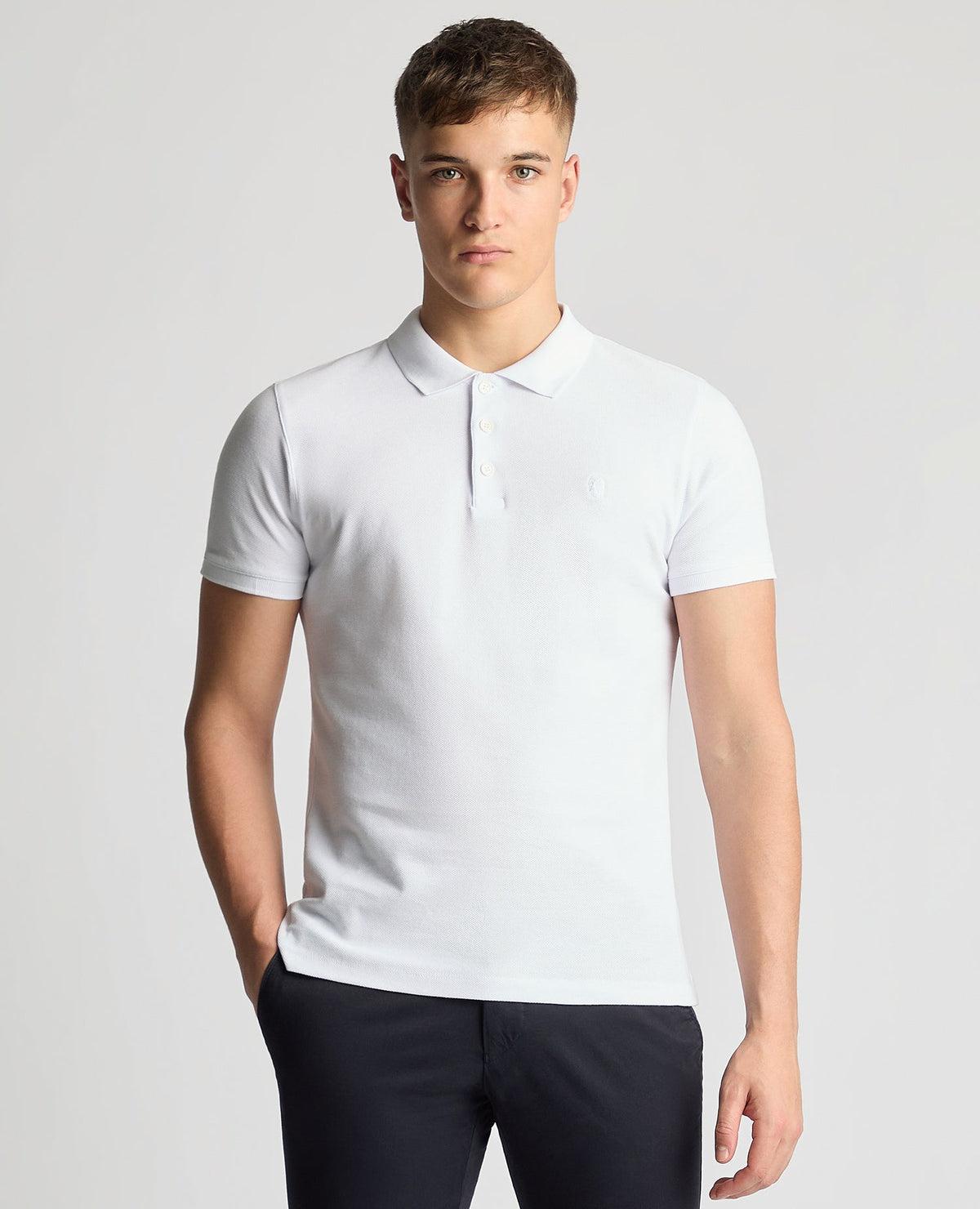 Man wearing a white Tapered Fit Cotton Pique Polo Shirt