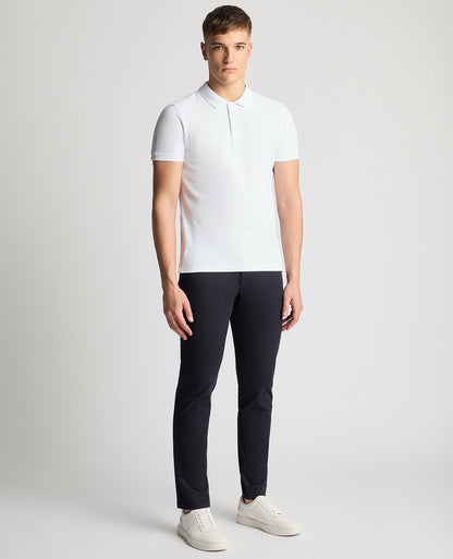 Man wearing a white Tapered Fit Cotton Pique Polo Shirt