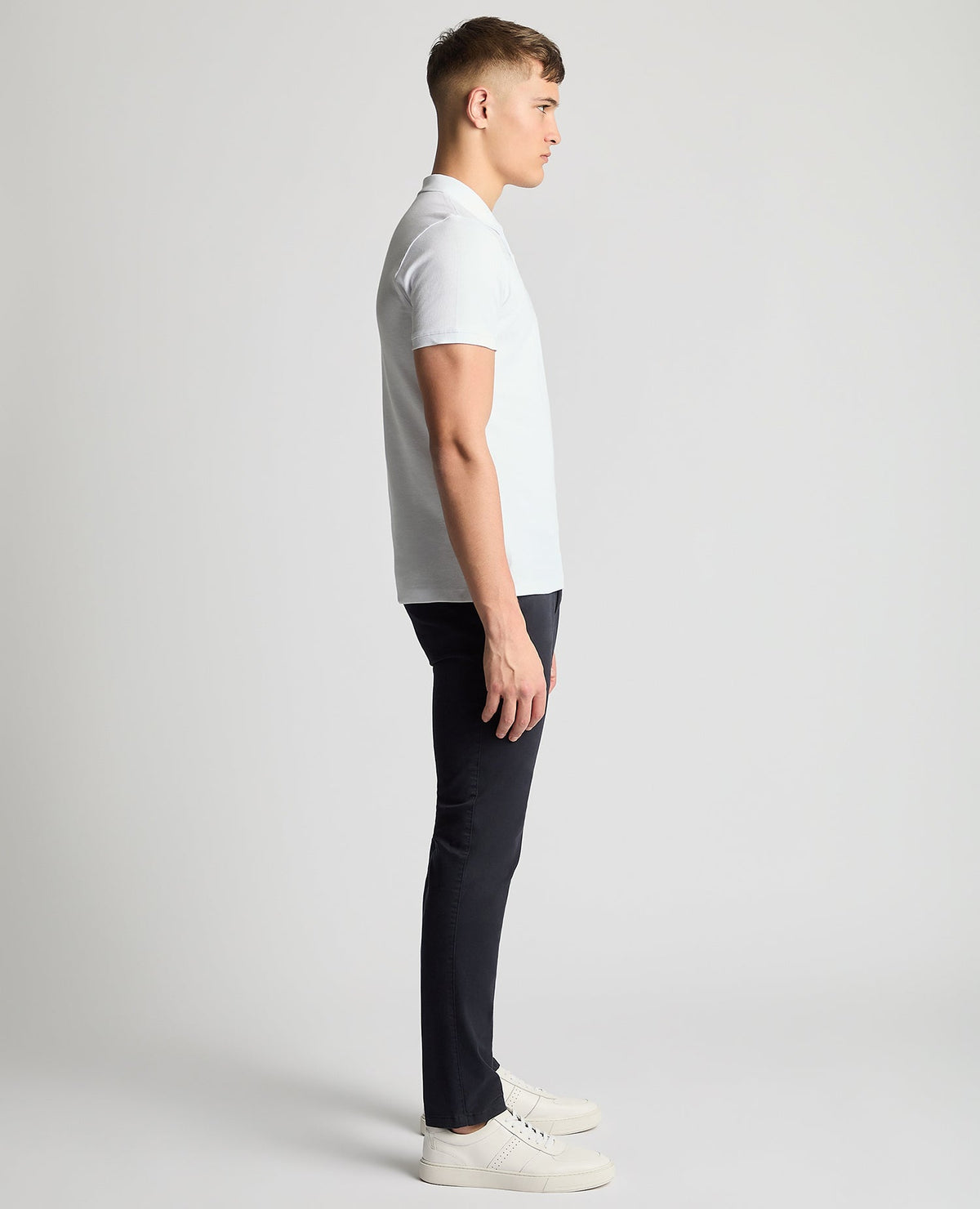 Man wearing a white Tapered Fit Cotton Pique Polo Shirt