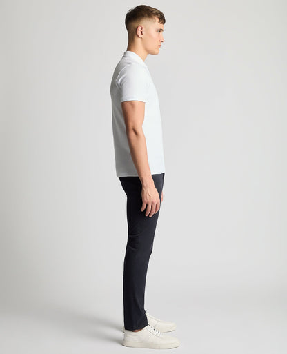 Man wearing a white Tapered Fit Cotton Pique Polo Shirt