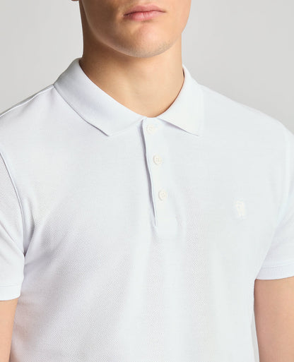 Man wearing a white Tapered Fit Cotton Pique Polo Shirt