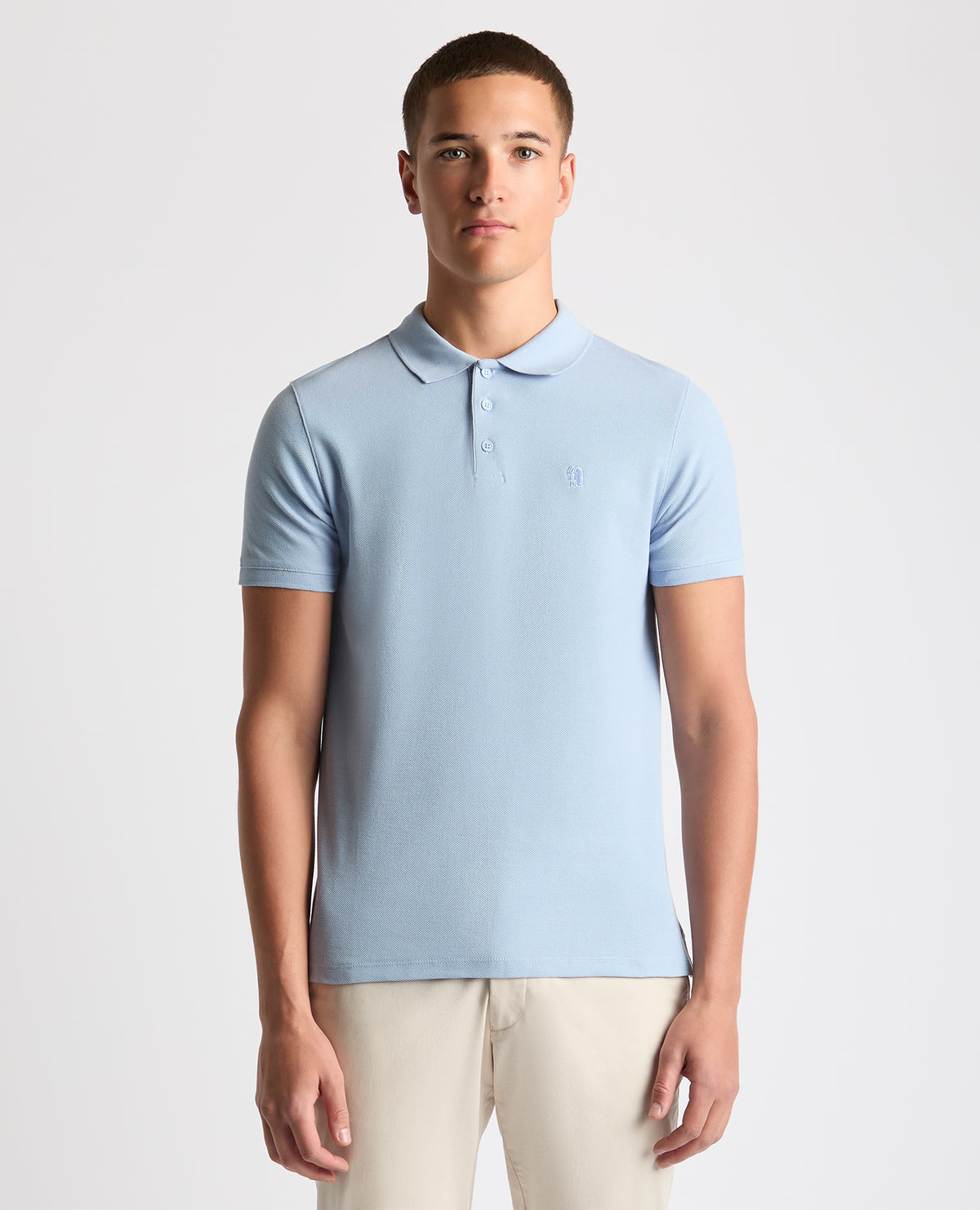 Man wearing a blue Tapered Fit Cotton Pique Polo Shirt