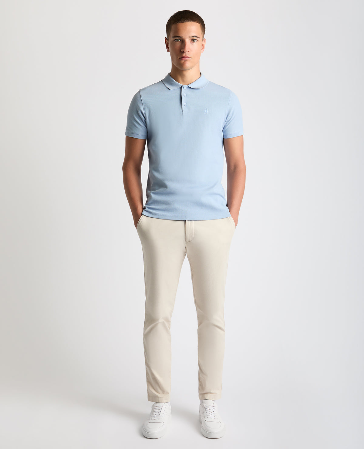 Man wearing a blue Tapered Fit Cotton Pique Polo Shirt